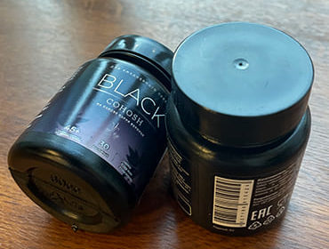 Два пузырька Black Cohosh на столе крупно.планом.
