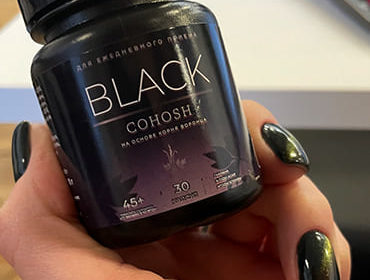 Препарат Black Cohosh в женской руке крупным планом.